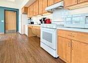 Thumbnail 14 of 21 - A kitchen with wooden cabinets and a white oven.