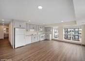 Thumbnail 46 of 58 - A spacious kitchen with white appliances and wooden floors.