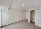 Thumbnail 45 of 58 - A spacious room with a carpeted floor and a closet with drawers.