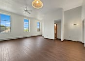 Thumbnail 5 of 20 - A room with a ceiling fan and wooden flooring.