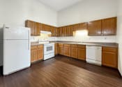 Thumbnail 4 of 20 - A kitchen with wooden cabinets and white appliances.