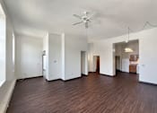 Thumbnail 8 of 20 - A spacious room with wooden flooring and a ceiling fan.