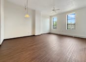 Thumbnail 7 of 20 - A room with wooden flooring and a ceiling fan.