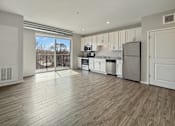 Thumbnail 19 of 31 - A kitchen with white cabinets and a wooden floor.