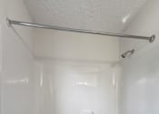 Thumbnail 11 of 28 - A white bathroom with a white tub and a white shower curtain.