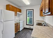 Thumbnail 15 of 28 - A kitchen with a white refrigerator and wooden cabinets.