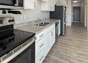 Thumbnail 18 of 31 - A kitchen with black appliances and white cabinets.