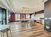 Thumbnail 16 of 31 - A modern kitchen with a dining table and chairs.