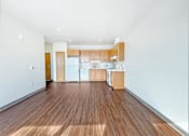 Thumbnail 4 of 21 - A kitchen with white appliances and wooden floors.