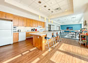 Thumbnail 13 of 21 - A kitchen with wooden floors and a white refrigerator.