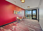 Thumbnail 10 of 31 - A hallway with a red wall and a painting hanging on it.