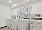 Thumbnail 15 of 46 - A row of washing machines in the Stryker Senior Apartments in West St. Paul laundry room..
