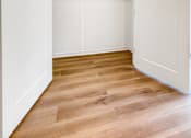 Thumbnail 5 of 37 - A white closet with a wooden floor and shelves.