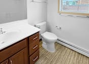 Thumbnail 16 of 27 - A bathroom with a toilet, sink, and mirror.