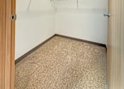Thumbnail 7 of 21 - A walk-in closet with shelves and a carpeted floor.