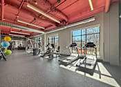 Thumbnail 12 of 31 - A gym with treadmills, exercise balls, and weights.