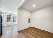 Thumbnail 4 of 37 - A room with wooden floors and white walls.