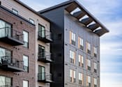 Thumbnail 2 of 31 - A modern apartment building with balconies on the second floor.