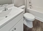 Thumbnail 7 of 31 - A white toilet sits next to a white sink in a bathroom.