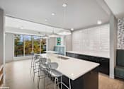 Thumbnail 19 of 58 - A modern kitchen with a large island and chairs.