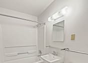 Thumbnail 28 of 29 - A white bathroom with a toilet, sink, and bathtub.