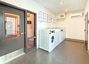 Thumbnail 16 of 21 - A laundry room with a washer and dryer.