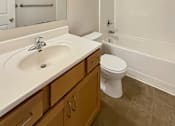 Thumbnail 11 of 15 - A bathroom with a sink, toilet, and bathtub.
