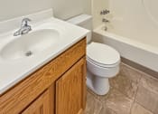 Thumbnail 10 of 10 - A white sink with a silver faucet is on a countertop next to a white toilet.