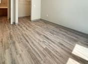 Thumbnail 10 of 20 - A room with a wooden floor and a light on the ceiling.
