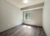 Thumbnail 9 of 20 - A room with wooden flooring and a window.