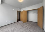 Thumbnail 10 of 35 - A room with a carpeted floor and a wooden door.
