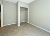 Thumbnail 11 of 20 - A room with a grey wall and a wooden floor.
