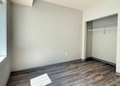 Thumbnail 8 of 20 - A room with a wooden floor and a white wall.