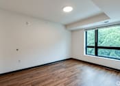 Thumbnail 38 of 46 - an empty living room at Stryker Senior Apartments in West St Paul with wood floors and a large window