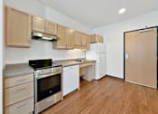 Thumbnail 16 of 46 - A studio apartment kitchen at Stryker Senior Apartments in West St. Paul with wooden cabinets and stainless steel appliances.