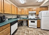 Thumbnail 9 of 16 - A kitchen with wooden cabinets and a white refrigerator.