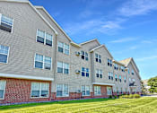 Thumbnail 7 of 16 - A large apartment building with multiple windows and balconies.