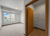 Thumbnail 20 of 35 - A bedroom with walk in closet and window in the background
