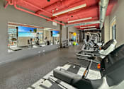 Thumbnail 13 of 31 - A gym with treadmills, exercise bikes, and other equipment.