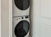 Thumbnail 8 of 31 - Two white front loading washing machines in a small laundry room.