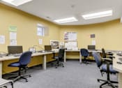 Thumbnail 14 of 15 - A yellow office space with multiple desks and computers.