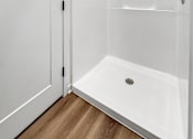 Thumbnail 8 of 37 - A white bathroom with a walk-in shower and a white door.