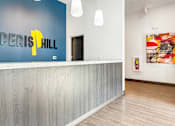Thumbnail 2 of 37 - A reception area with a blue wall and a white reception desk.