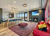 Thumbnail 17 of 31 - A modern living room with a red couch and a fireplace.
