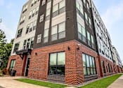 Thumbnail 2 of 22 - A modern multi-story building with a combination of brick and panel facades.