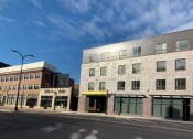 Thumbnail 18 of 37 - a brick building with a silver roof on a city street