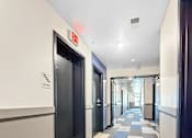 Thumbnail 20 of 22 - A long hallway with a blue and white checkered floor.