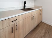 Thumbnail 3 of 43 - A kitchen with wooden cabinets and a white countertop.