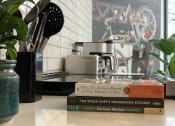 Thumbnail 27 of 37 - a stack of books sitting on a counter in a kitchen
