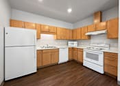 Thumbnail 4 of 35 - A kitchen with wooden cabinets and white appliances.